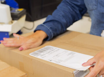 Pair of hands labeling a box.