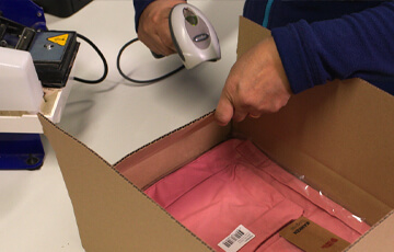 A box with pink contents being scanned.